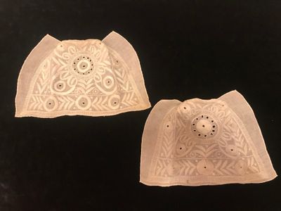 two pieces of white lace on a black background