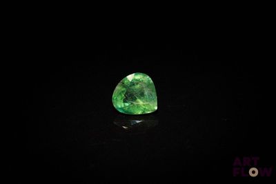 un gros plan d'une émeraude verte sur une surface noire