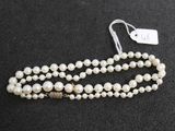 gros plan d'un collier de perles sur une surface noire