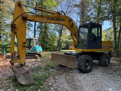une pelleteuse jaune qui est immobilisée dans la terre