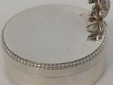 un plat ancien en argent sur lequel est perché un oiseau