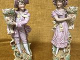 une paire de figurines représentant un garçon et une fille tenant des fleurs