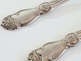 two spoons that are sitting on a white table