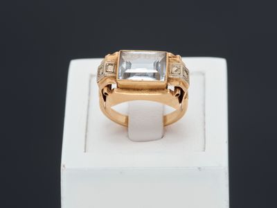 un gros plan d'une bague en or sertie d'une pierre blanche