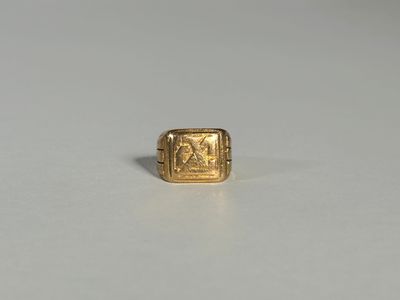 un gros plan d'une bague en or sur laquelle figure l'image d'un homme