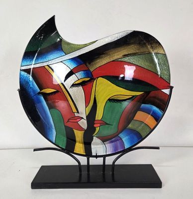 une sculpture en verre représentant le visage d'une femme, posée sur un socle