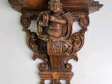 une photo d'une étagère en bois sur laquelle est posée une statue