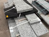 Plusieurs blocs de granit sont empilés les uns sur les autres dans un entrepôt