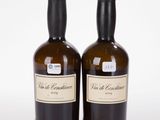 deux bouteilles de vin posées l'une à côté de l'autre sur une surface blanche