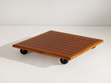 une image représentant une petite table en bois munie de roulettes, posée sur une surface blanche