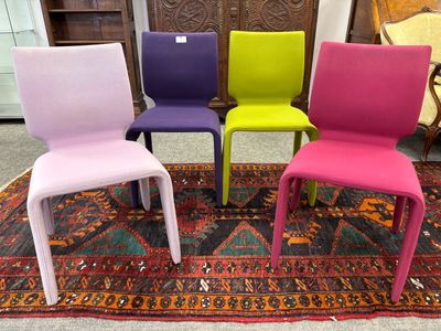 trois chaises colorées posées sur un tapis posé à son tour sur un autre tapis