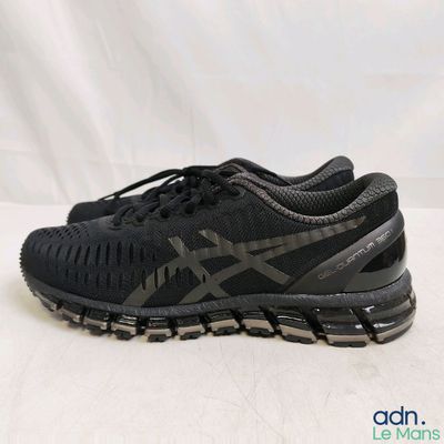 a close up of a pair of black running shoes on a white surface