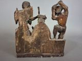 wooden sculpture of three men playing a game of chess on a table