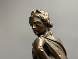a bronze statue of a boy with a scarf around his neck