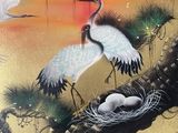 deux oiseaux perchés dans un nid sur un arbre