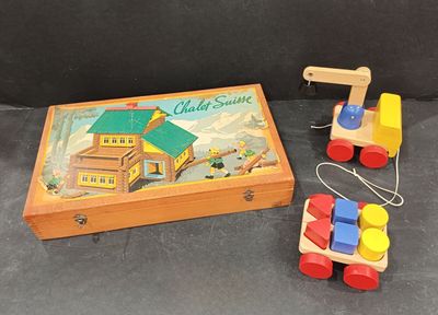 une boîte en bois contenant un petit train et une boîte en bois sur laquelle est dessinée une maison