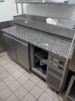 a kitchen with a counter, refrigerator, and sink in it