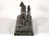 bronze statue of a horse and a man on a horse drawn carriage