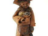 figurine représentant un homme coiffé d'un chapeau, tenant un oiseau dans ses mains