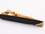 black and gold tie bar with diamond accents on a white background