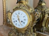 a clock that is sitting on a table in front of a mirror