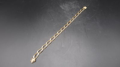 a close up of a gold chain bracelet on a black surface