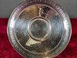 a silver plate on a red cloth on a red surface