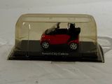 a small red car in a clear case on a white surface