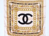 a chanel scarf with gold chains and a black and white logo