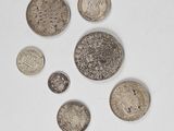 several coins are arranged in a circle on a white surface