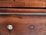 a close up of a wooden dresser with brass knobs