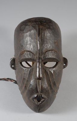 une image représentant un masque en bois entouré d'une corde