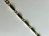 a close up of a green bracelet on a white surface