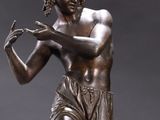 bronze statue of a man holding a tennis racquet on a marble base