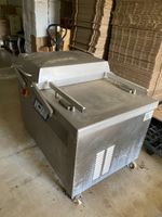 Une vieille emballeuse sous-vide double-cloche en inox