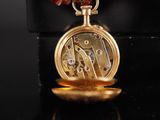 an image of a gold pocket watch with a red flower on it