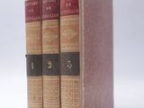 trois livres sont empilés sur une surface blanche