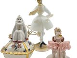 three figurines of a woman and a child on a plate