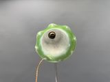 une fleur verte et blanche au sommet d'un poteau métallique