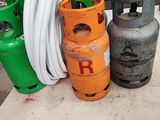 three propane gas cylinders on a table with a hose