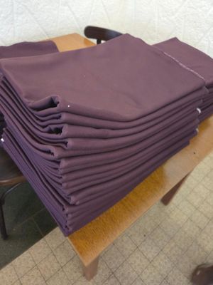 une pile de serviettes violettes pliées posée sur une table en bois