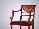 une image représentant une chaise rouge sur laquelle est posé un coussin noir