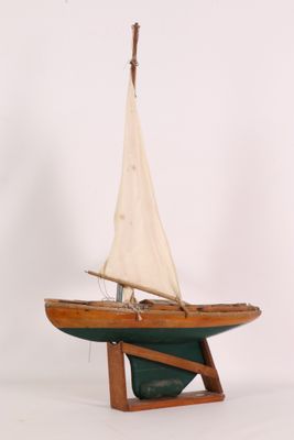a small wooden sailboat on a stand on a white background