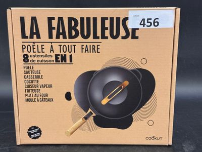 emballage d'une poêle noire munie d'un manche en bois, posé sur une table
