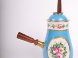 a blue tea pot with a wooden handle on a white background