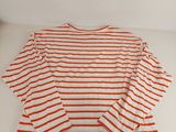 an orange and white striped shirt on a white surface