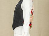 a mannequin wearing a black vest and white pants