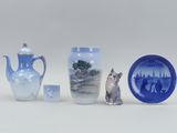 three vases and a plate with a cat on them