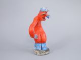 figurine of a red and blue bird on a white base