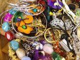 a wooden bowl filled with assorted jewelry on a table